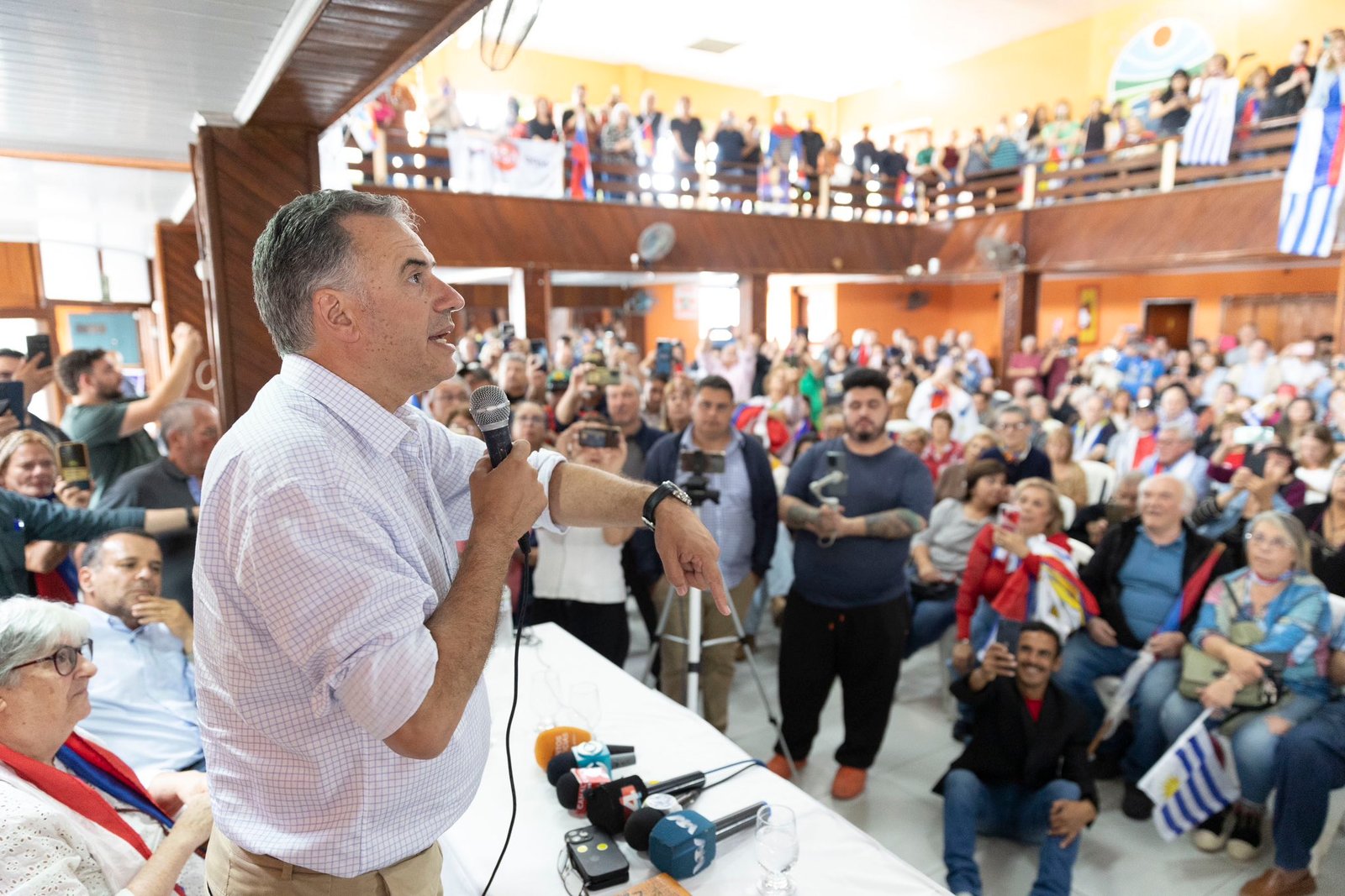 Orsi camisa blanca de perfil mira hacia la derecha a la multitud